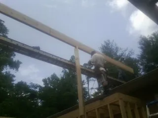 Carpenter setting a ridge beam over a new addition frame — Ice Dam Removal by Roofing Brothers in Stevens