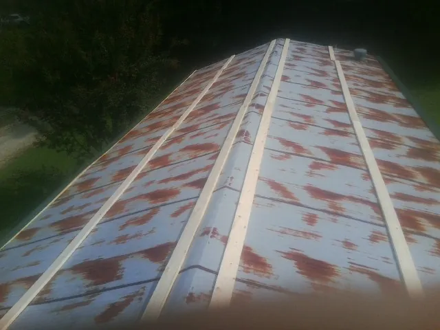 Rusted metal roof panels with new wood purlins before replacement — Storm Damage Roof Repair in Stevens by Roofing Brothers
