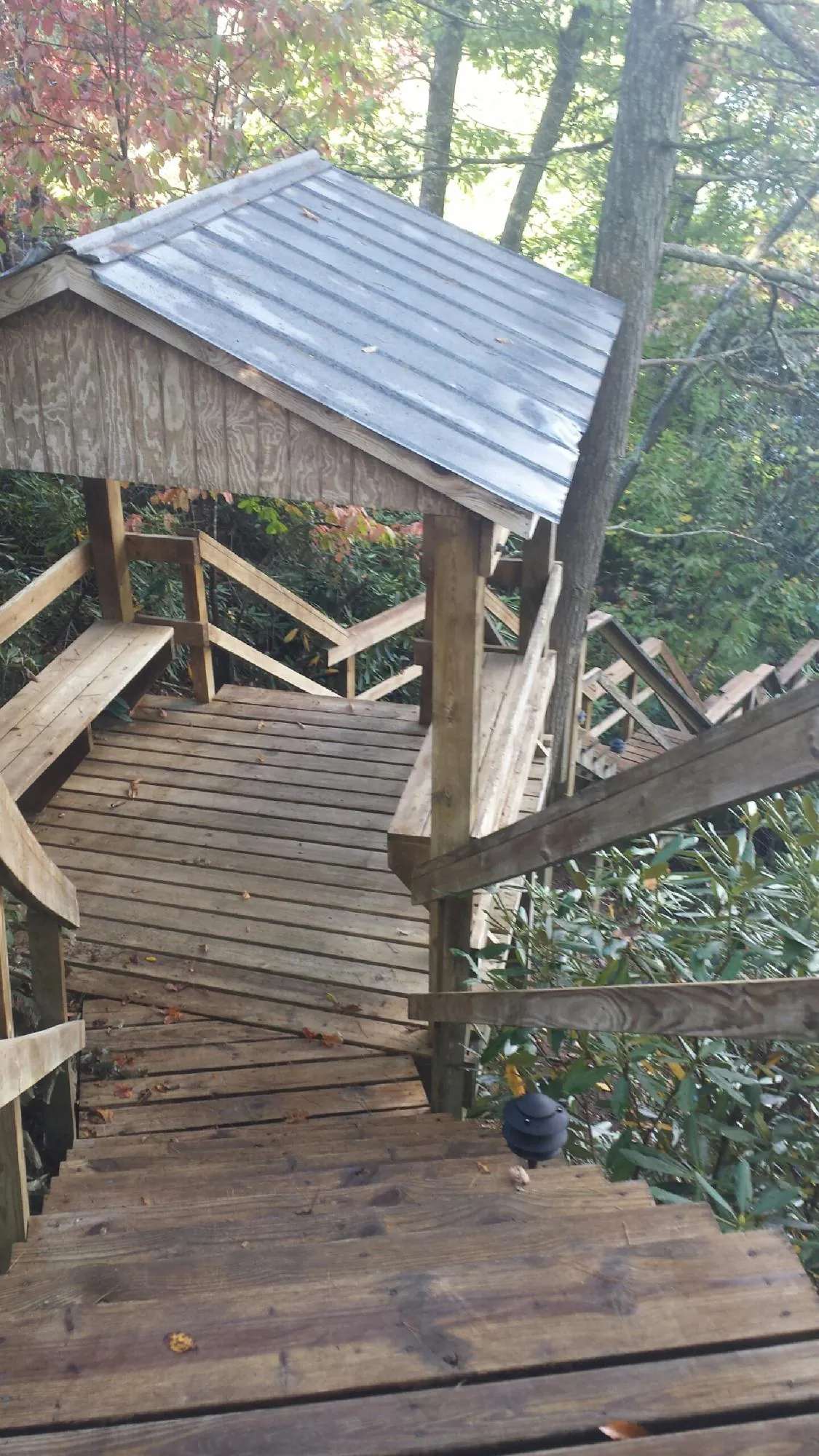 Metal roofed shelter over wooden steps on a wooded walkway — Skylight Repair & Installation work by our crew in Stevens