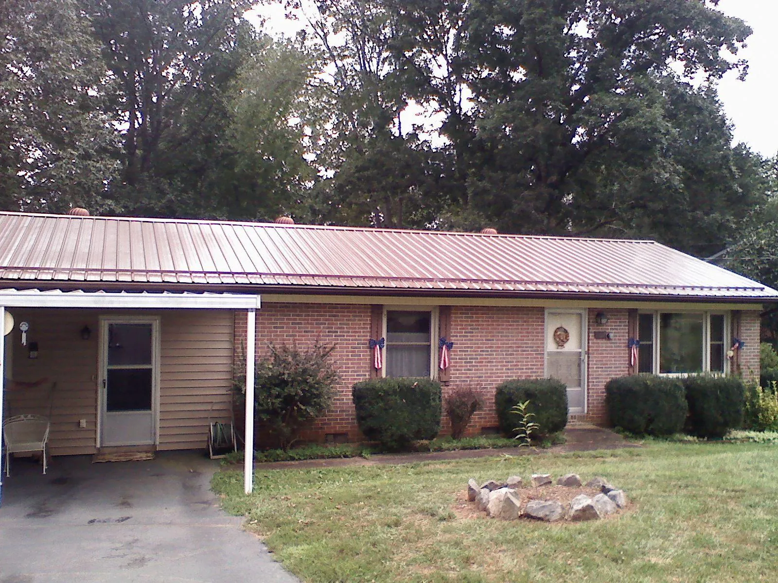 Bronze metal roof and carport on a brick ranch home — Roof Repair work by our crew in Stevens